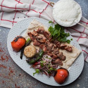 Top view shish kebab with tomato and onion and ayran on stone background